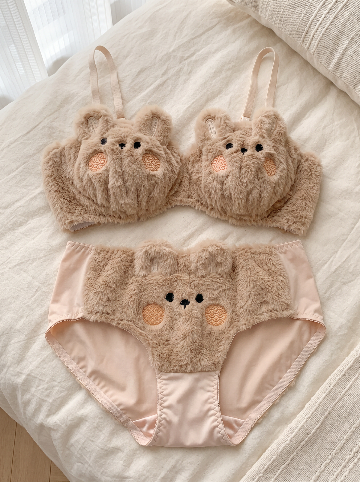 Bear bra and brief laid flat on cream linen